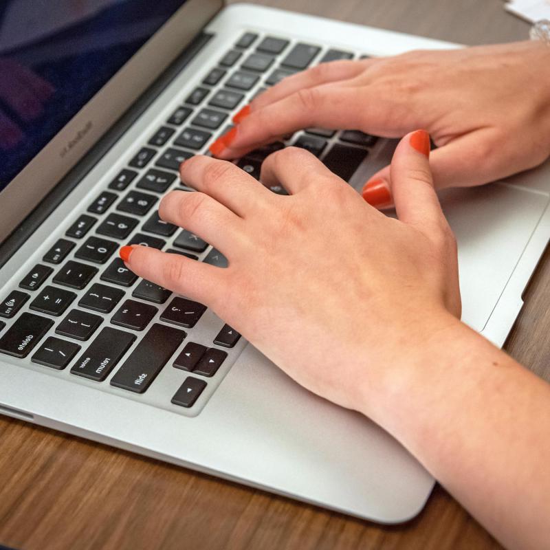 Hands typing on a laptop.